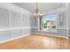 Bright dining room with hardwood floors, decorative trim, large windows, and elegant chandelier at 9112 Butterfly Ct, Gastonia, NC 28056