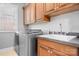 Well-equipped laundry room features wood cabinets, a sink, countertop space, and a modern washer and dryer at 9112 Butterfly Ct, Gastonia, NC 28056