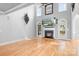 Open living room with hardwood floors, fireplace, ceiling fan, and large windows that allows natural light at 9112 Butterfly Ct, Gastonia, NC 28056