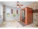 Bright sunroom with brick accent wall, tiled flooring, and a personal sauna at 9112 Butterfly Ct, Gastonia, NC 28056