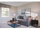 Sunlit living room showcases a gray sofa, patterned pillows, and a stylish coffee table at 10116 Florentine Way, Charlotte, NC 28214