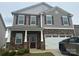 Charming two-story home with stone and gray siding, complemented by a two-car garage at 9730 Tea Garden Dr, Gastonia, NC 28056