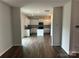 Open-concept view of a modern kitchen with white cabinets, stainless appliances, and a center island at 9730 Tea Garden Dr, Gastonia, NC 28056