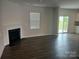 Bright living room features dark wood floors, a fireplace, and sliding glass doors leading to the outdoors at 9730 Tea Garden Dr, Gastonia, NC 28056