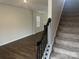Open-concept living area with wood floors and staircase with carpet runner at 9730 Tea Garden Dr, Gastonia, NC 28056
