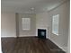 Bright living room featuring wood floors, a cozy fireplace, and large windows for natural light at 9730 Tea Garden Dr, Gastonia, NC 28056