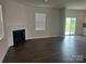 Bright living room features dark wood floors, a fireplace, and sliding glass doors leading to the outdoors at 9730 Tea Garden Dr, Gastonia, NC 28056
