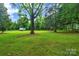Lush green backyard featuring mature trees, a mobile home and an outdoor play set at 9929 Kerns Rd, Huntersville, NC 28078