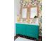 Stylish bathroom featuring a double vanity with colorful wallpaper and brick floor at 9929 Kerns Rd, Huntersville, NC 28078