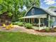 Charming home exterior featuring a wrap-around porch, yellow chairs on patio, and a classic barn at 9929 Kerns Rd, Huntersville, NC 28078