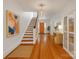 Bright foyer with hardwood floors, a staircase, and a pop of color from an orange door at 9929 Kerns Rd, Huntersville, NC 28078