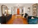Welcoming foyer with hardwood floors, a bright orange door, and stylish decor at 9929 Kerns Rd, Huntersville, NC 28078