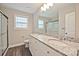Bathroom with double sink vanity, granite countertops, and glass-enclosed shower at 1028 Gibson St, Albemarle, NC 28001
