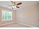 A light-filled room featuring neutral carpeting, a ceiling fan, and a bright window at 1028 Gibson St, Albemarle, NC 28001