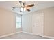 A bedroom featuring neutral carpeting, a ceiling fan, a window, and closet space at 1028 Gibson St, Albemarle, NC 28001