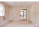 Bedroom with neutral carpet, paneled wallpaper, and a large mirrored closet at 105 Hopewell Church Rd, Shelby, NC 28152