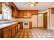 Kitchen featuring wood cabinets, white appliances, and unique tile flooring at 105 Hopewell Church Rd, Shelby, NC 28152
