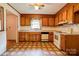 Kitchen featuring wood cabinets, white appliances, and unique tile flooring at 105 Hopewell Church Rd, Shelby, NC 28152