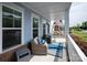 Cozy front porch featuring cushioned wicker chairs, blue rug and pillows, and freshly painted siding at 1100 Herrons Ferry Rd, Rock Hill, SC 29730