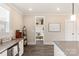 Bright kitchen featuring white cabinets, gray countertops, subway tile backsplash and a hallway leading to a mudroom at 1100 Herrons Ferry Rd, Rock Hill, SC 29730