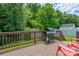 Back deck featuring a grill, dark wood planks, red chairs, and backyard views at 1209 Danielle Downs Se Ct, Concord, NC 28025