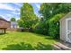 Well-maintained backyard featuring lush green grass, mature trees, and privacy shrubs at 1209 Danielle Downs Se Ct, Concord, NC 28025