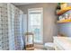 Cozy bathroom featuring a shower with geometric patterned curtain and open wooden shelving at 1209 Danielle Downs Se Ct, Concord, NC 28025