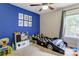 bedroom featuring race car themed bed, blue accent wall with posters, and a window for natural light at 1209 Danielle Downs Se Ct, Concord, NC 28025