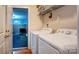 Laundry room featuring side-by-side washer and dryer, with easy access to storage shelving and basement at 1209 Danielle Downs Se Ct, Concord, NC 28025