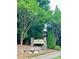 Emerald Green Village entrance sign surrounded by lush greenery, creating a serene welcome at 128 Aztec Cir, Mooresville, NC 28117
