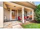 Inviting front porch with stone flooring, comfortable seating, and a decorative door wreath for curb appeal at 128 Aztec Cir, Mooresville, NC 28117