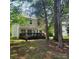 Large backyard featuring a wooden deck and ample green space, surrounded by mature trees at 13039 Peacock Ln, Charlotte, NC 28215