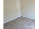 A secondary bedroom featuring neutral walls and carpet with standard door and baseboard trim at 13039 Peacock Ln, Charlotte, NC 28215
