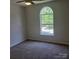 A well-lit bedroom features neutral paint, carpet and a large arched window at 13039 Peacock Ln, Charlotte, NC 28215