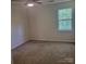 A carpeted bedroom with neutral colors and a window for plenty of natural light at 13039 Peacock Ln, Charlotte, NC 28215