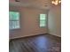 A spacious secondary bedroom with wood floors and two windows at 13039 Peacock Ln, Charlotte, NC 28215