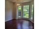Bright dining area featuring hardwood floors, a chandelier, and a bay window with backyard views at 13039 Peacock Ln, Charlotte, NC 28215
