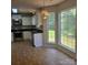 Kitchen eat-in area with tile flooring, modern white cabinets and stainless steel appliances at 13039 Peacock Ln, Charlotte, NC 28215