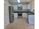 Kitchen with stainless steel appliances, tile flooring, stone backsplash, and white cabinets at 13039 Peacock Ln, Charlotte, NC 28215