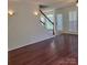 Spacious living room showcasing hardwood floors, staircase, decorative sconces and natural light at 13039 Peacock Ln, Charlotte, NC 28215