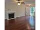 Comfortable living room with hardwood flooring, white fireplace, ceiling fan, and natural light at 13039 Peacock Ln, Charlotte, NC 28215