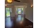 Open living area with hardwood flooring, a door to a patio, and natural light from multiple windows at 13039 Peacock Ln, Charlotte, NC 28215