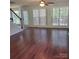 Bright living room featuring hardwood floors, a ceiling fan, and large windows at 13039 Peacock Ln, Charlotte, NC 28215