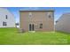A spacious backyard with lush green grass and a modern two-story home featuring a sliding glass door at 146 Astor St, Troutman, NC 28166