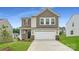 Charming two-story home boasts a two-car garage, manicured lawn, and welcoming front entrance at 146 Astor St, Troutman, NC 28166