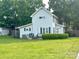 Spacious backyard featuring a well-maintained lawn, a small deck, and mature trees providing shade at 156 Spruce St, Badin, NC 28009