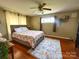 Bedroom features a bed with a patterned comforter, ceiling fan, and wood flooring at 156 Spruce St, Badin, NC 28009