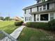Charming two-story home with white siding, black shutters, and manicured landscaping in the front yard at 156 Spruce St, Badin, NC 28009
