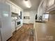 Well-lit kitchen with white cabinets, modern appliances, and laminate flooring for functional food preperation space at 156 Spruce St, Badin, NC 28009