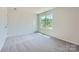 Bedroom featuring a large window, neutral carpet, white walls and trim at 157 Astor St, Troutman, NC 28166